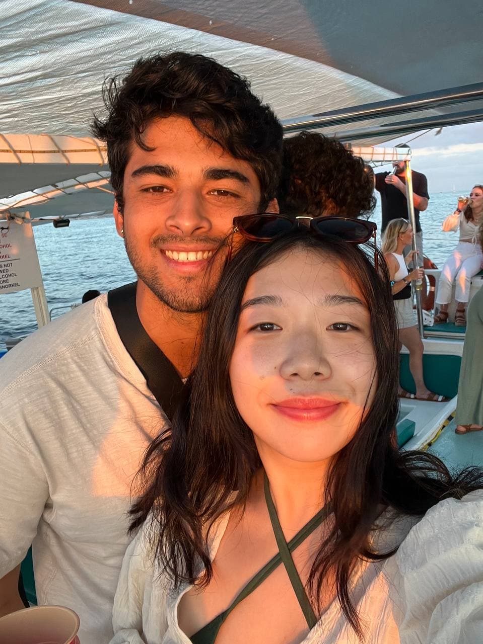 Amy and Roshan on a boat at sunset in Cabo